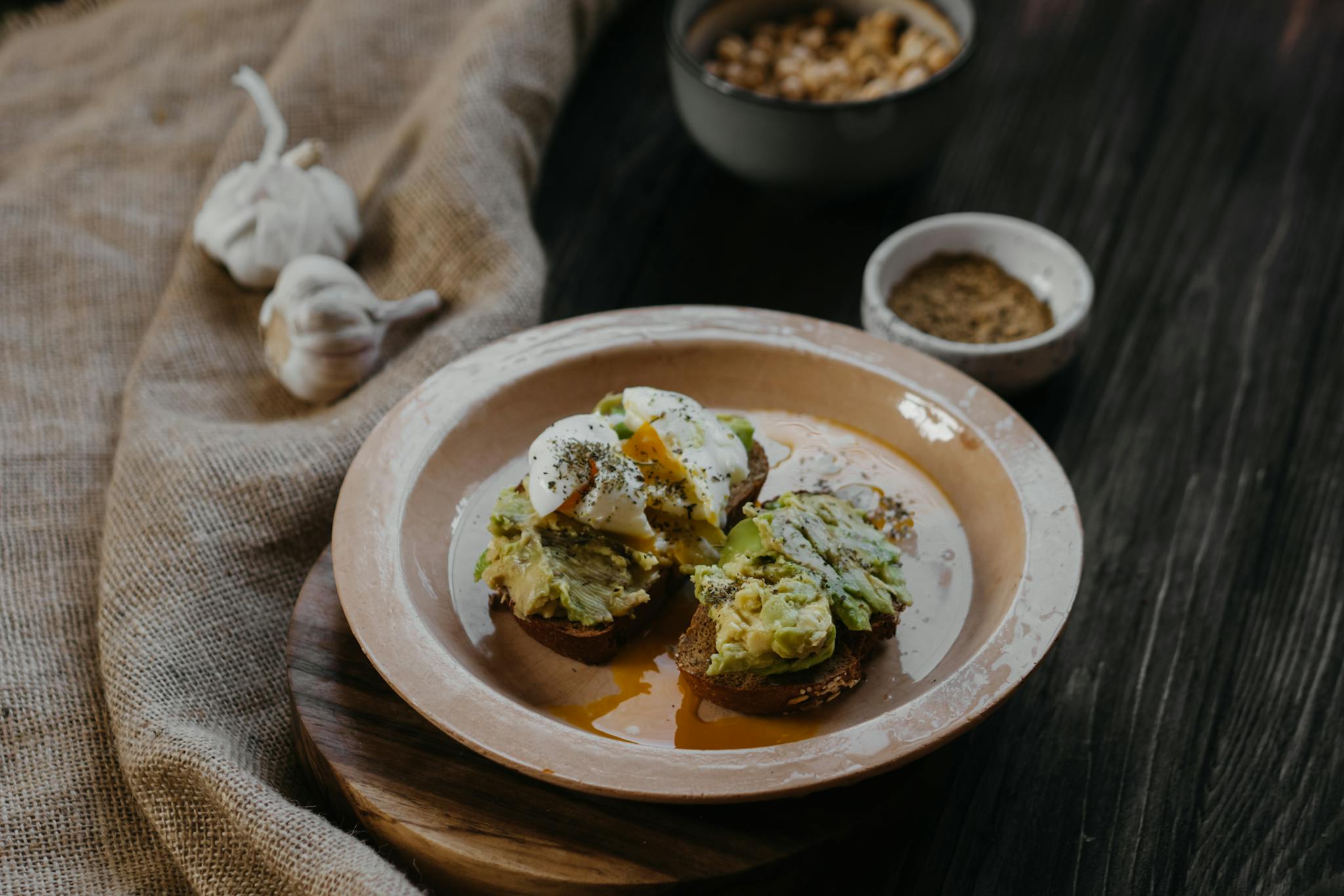 A rustic dish of avocado toast topped with poached eggs, perfect for a healthy breakfast.