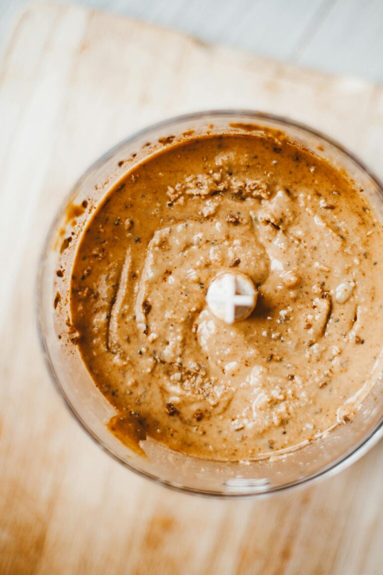 Top view of homemade brown nut butter in a blender, showcasing a healthy and nutritious breakfast option.